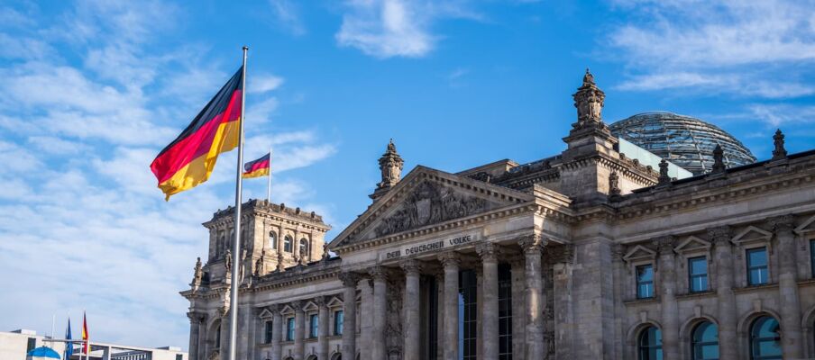 Flag of Germany with the Reichstag building The German flag with the Reichstag building in the background
