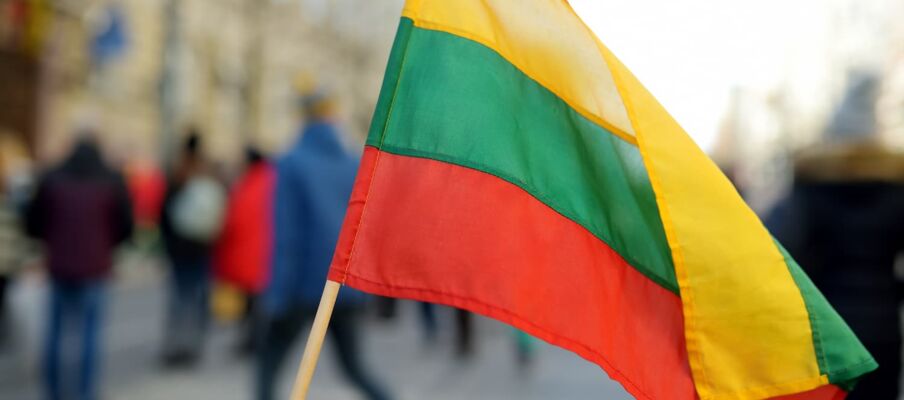 The flag of Lithuania with a busy city street in the background