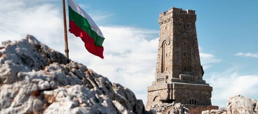 Flag of Bulgaria with stone monument The flag of Slovakia with a stone monument in the background